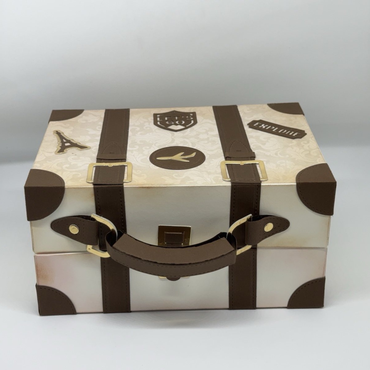 Geschenkbox in Form eines Vintage-Reisekoffers mit braunen Riemen, Griff und Reiseaufklebern