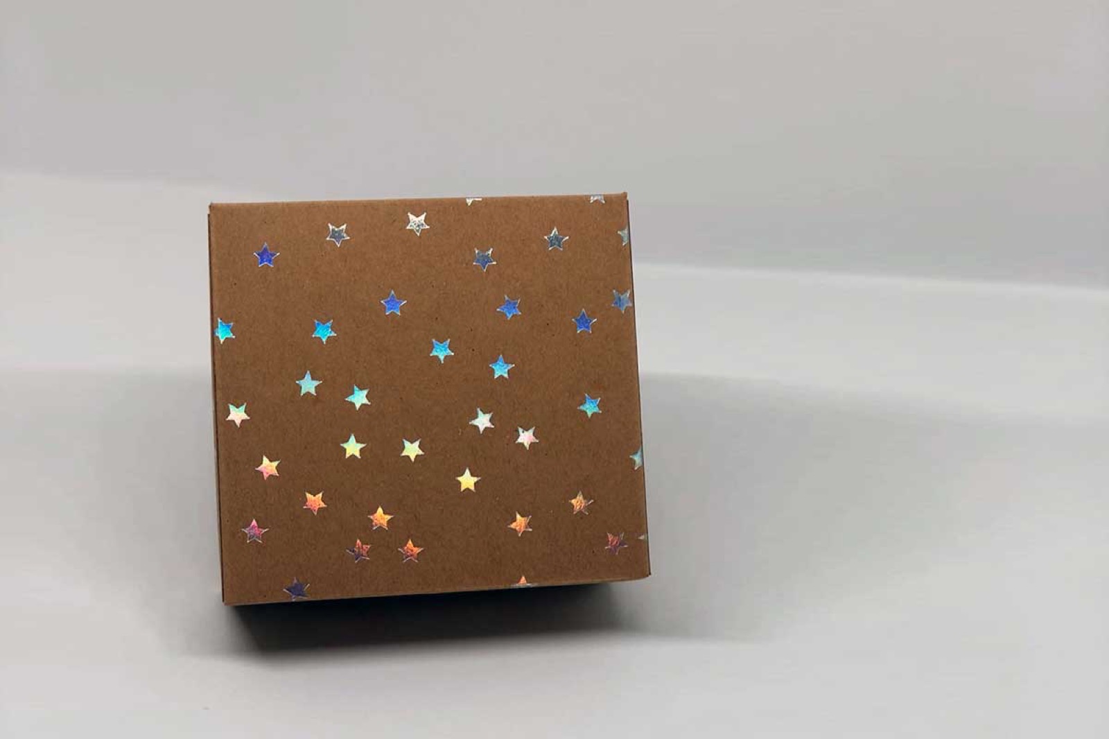 Flache Box aus Kraftpapier mit blauen und goldenen Punkten