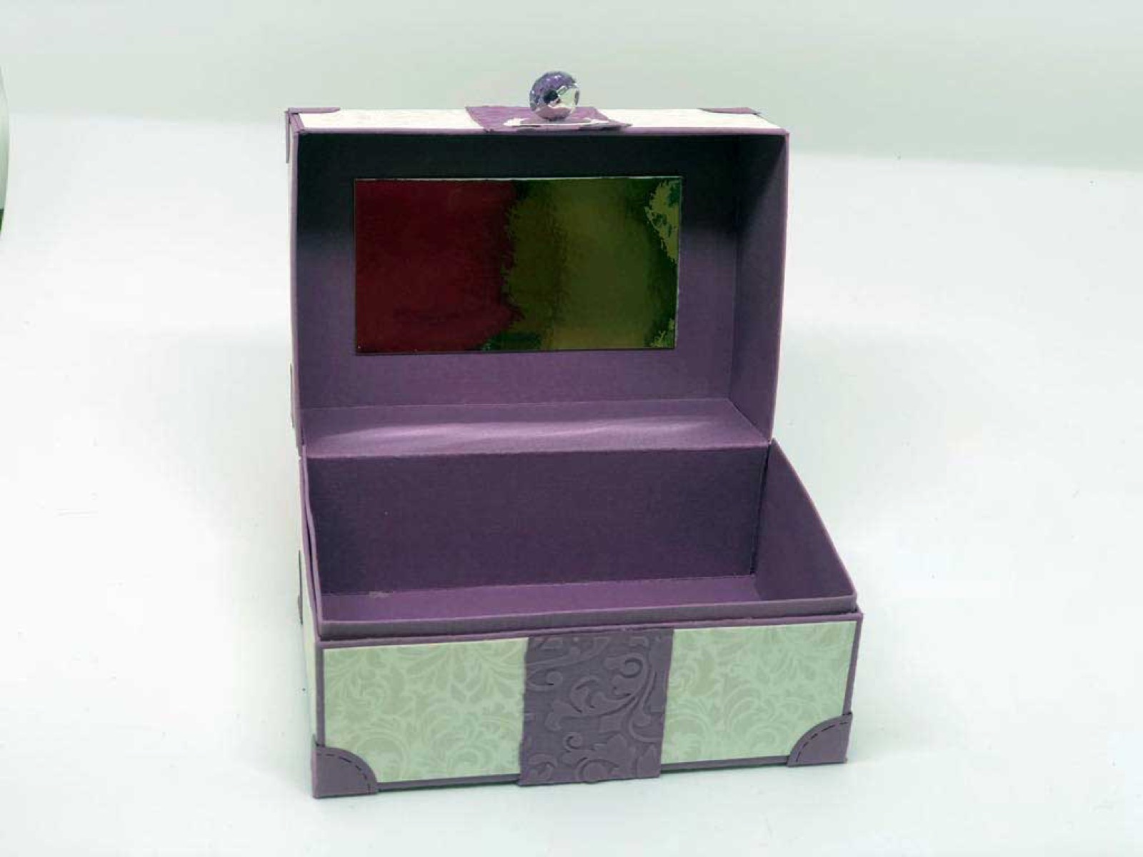 Geöffnete violette Box mit Spiegel im Deckel