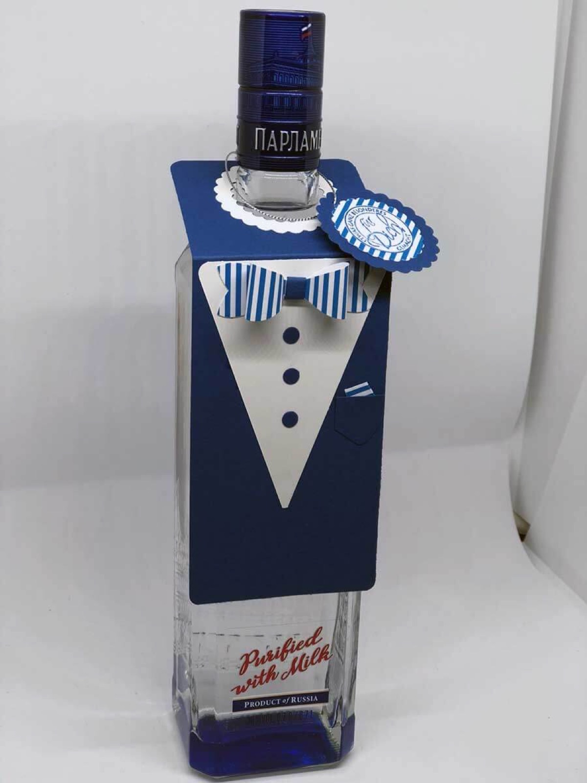Vodkaflasche in einem dunkelblauen Papieranzug mit Fliege und Kragen