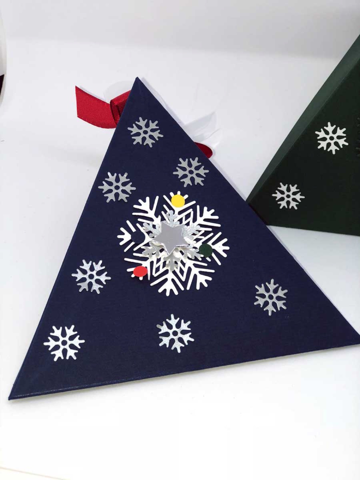 Blaue und grüne Weihnachtsbox in Dreiecksform nebeneinander