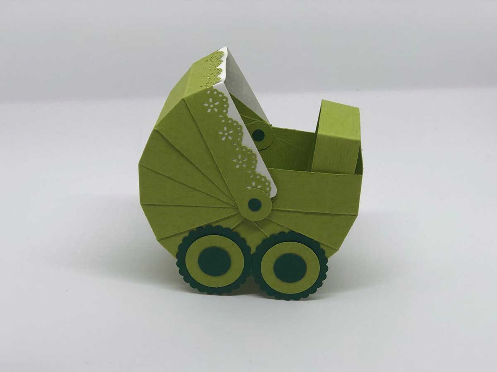 Kinderwagen aus olivgrünem Papier mit Rädern und Verdeck