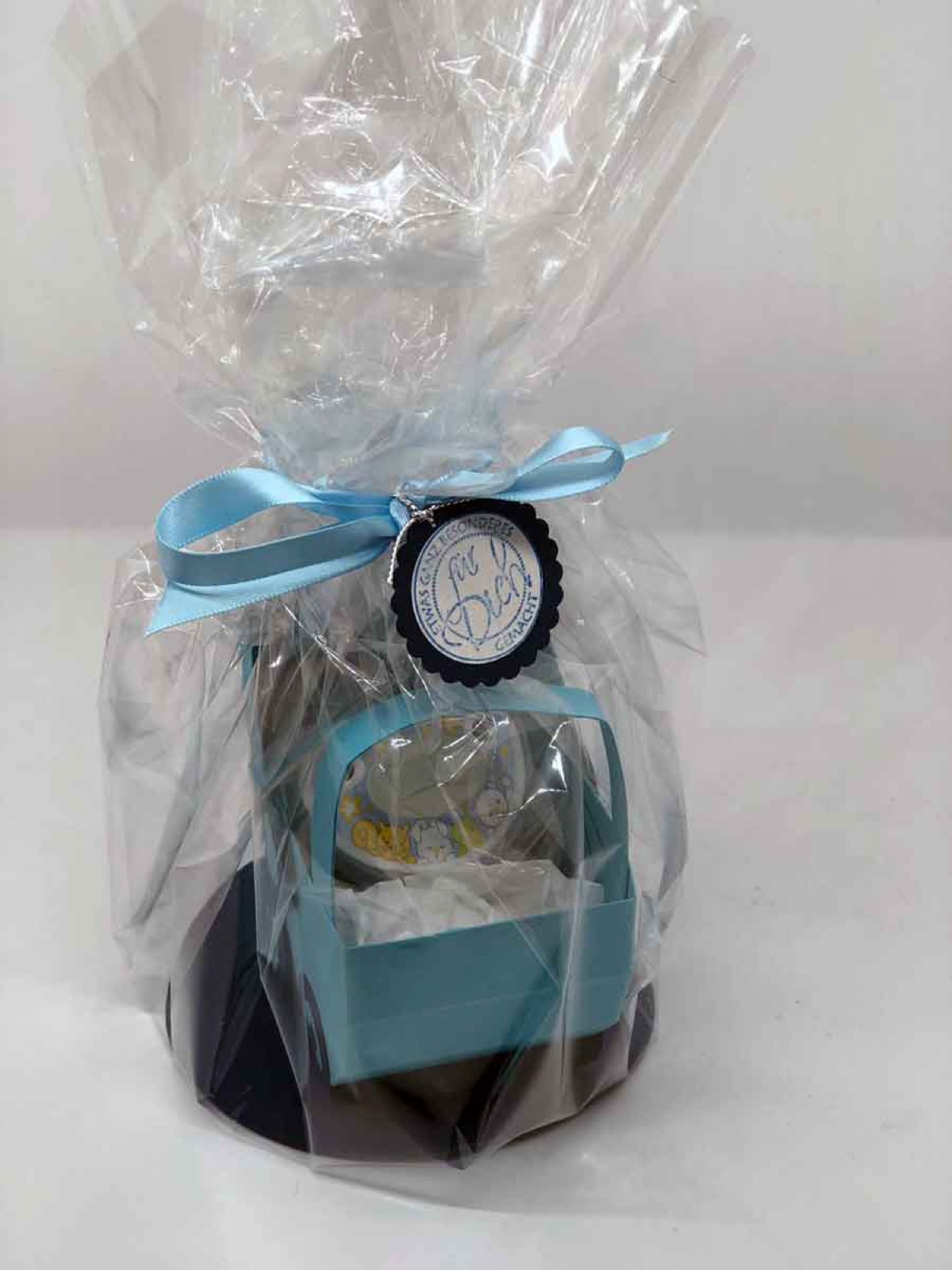 Verpacktes Babygeschenk mit blauer Schleife von der Seite