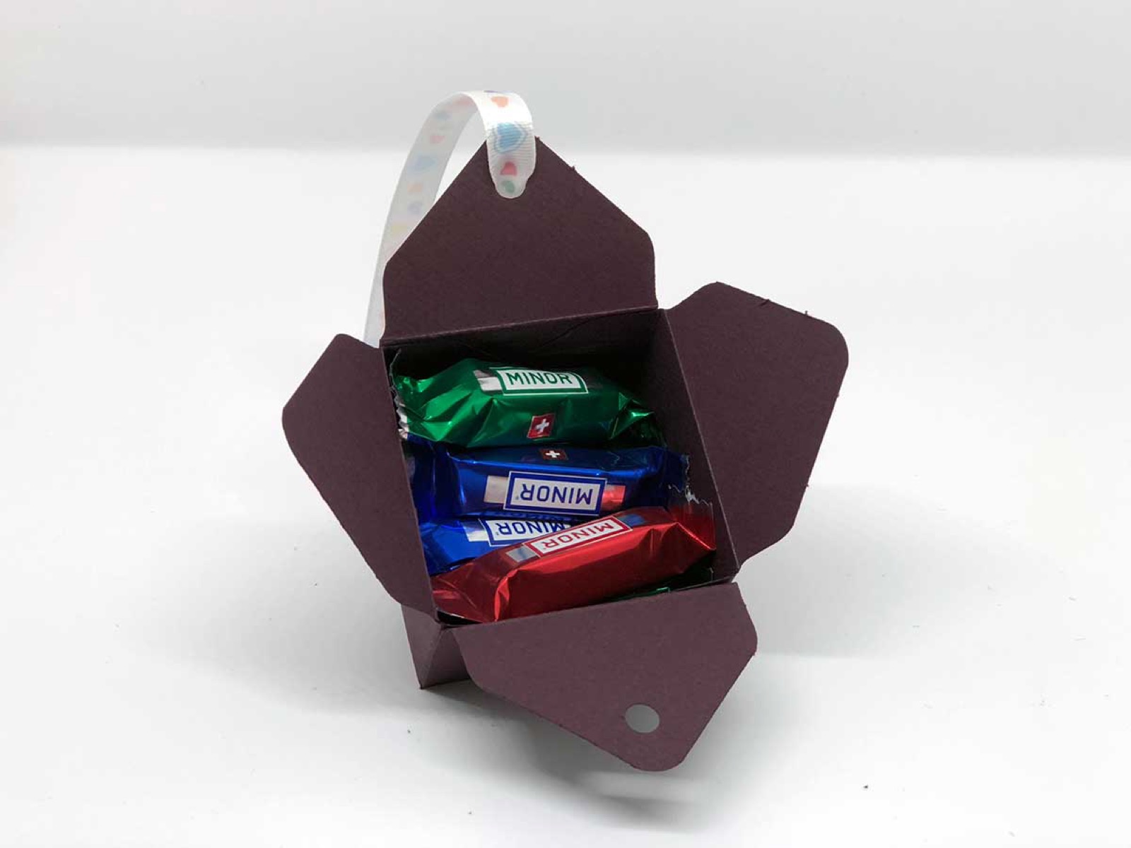 Geöffnete dunkelviolette Box mit Schokoriegeln darin
