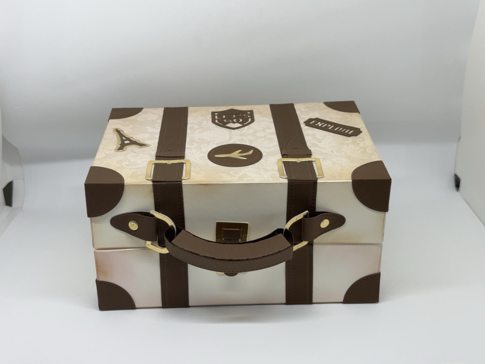 Geschenkbox in Form eines Vintage-Reisekoffers mit braunen Riemen, Griff und Reiseaufklebern